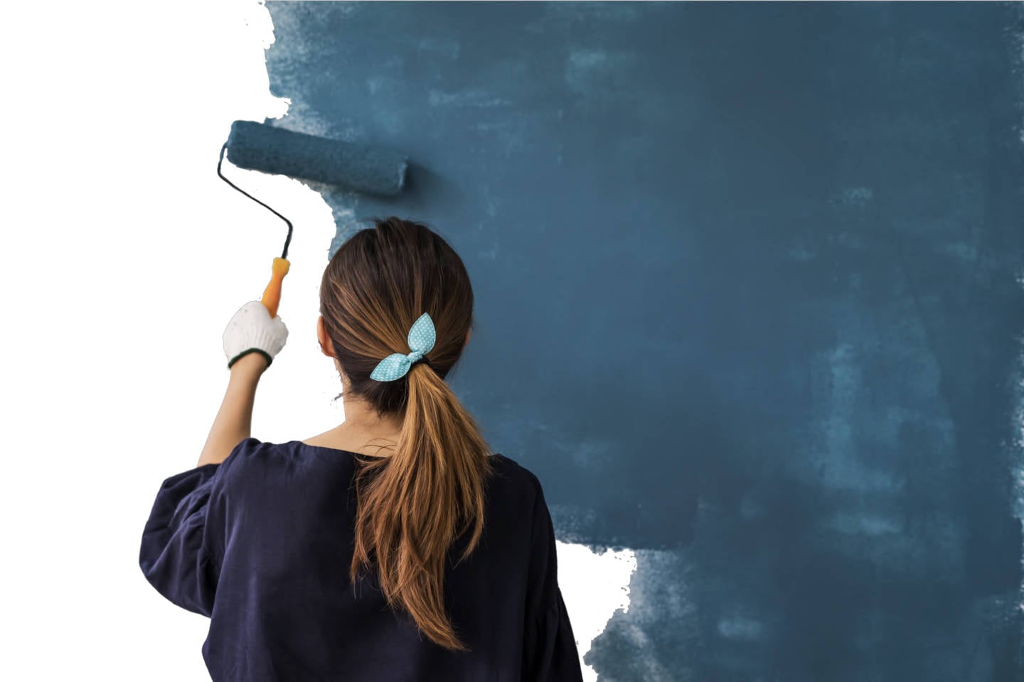 Female store associate painting a wall blue.