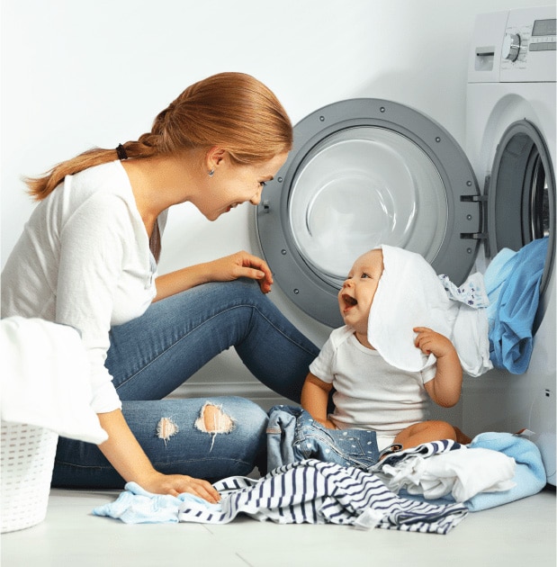 Mother and infant seated in front of open dryer