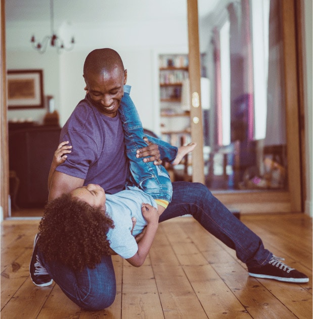 Father and daughter dancing on newly installed hardwood flooring.