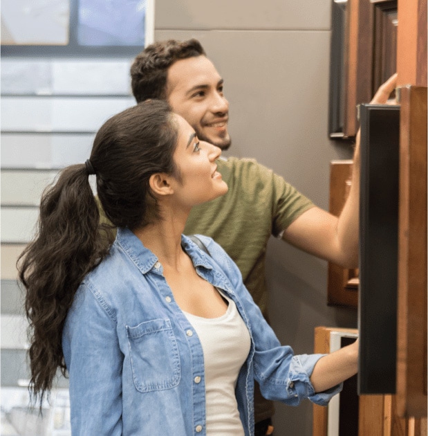 Young couple shopping for kitchen cabinets in home store.