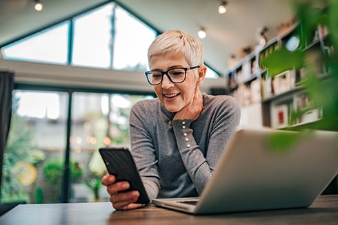 Woman sitting at desk talking on her cell phone.