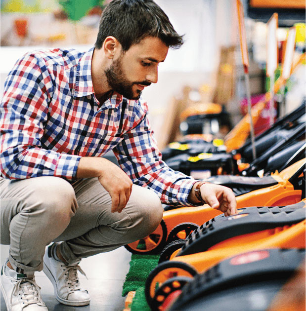 Man examining new electric lawn mowers.